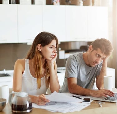 a man and woman sitting at a table with papers