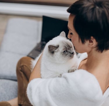 a woman in a bathrobear is holding a cat