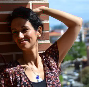 a woman in a floral dress standing on a balcony beatriz Alvarez