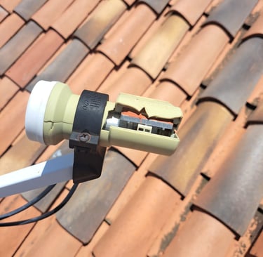 A broken dstv lnb  mounted on a satellite dish on a rooftop