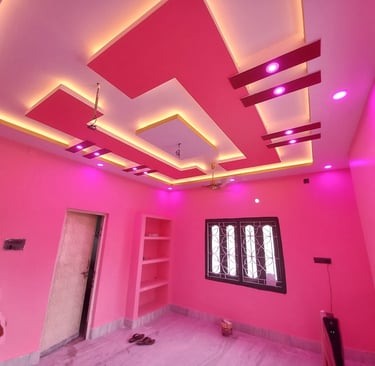 Modern pink bedroom interior featuring a vibrant false ceiling design with cove lighting and LED spotlights.