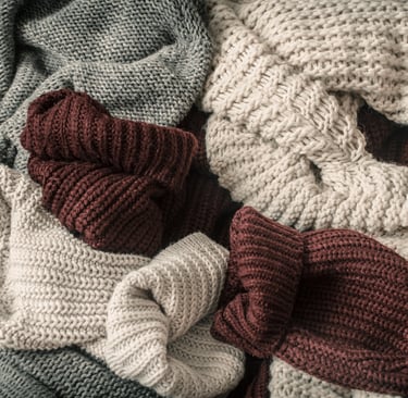 a pile of sweater knitted scarves and other wool materials