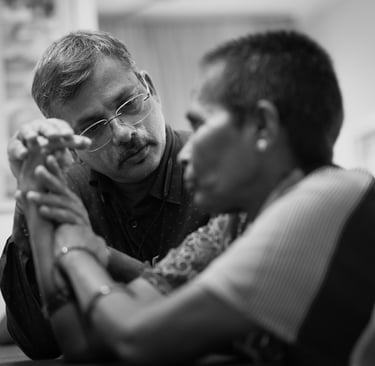 A doctor examines a patient's arm while listening attentively during a consultation in a clinical setting.