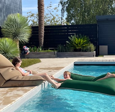 Coussins Biboo sur transats autour d’une piscine dans un hôtel de plein air