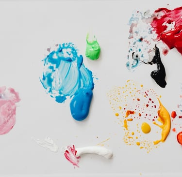 Abstract artistic colorful paint splatters and thick acrylic smears on a white background.