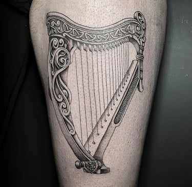 Tatouage d'une harpe celtique sur la cuisse.