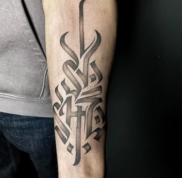 Tatouage d'un symbole typographique sur l'avant-bras.
