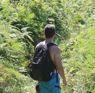a man walking down a path with a backpack