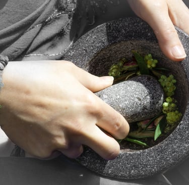 a person holding a mortar and pestle grinding herbs