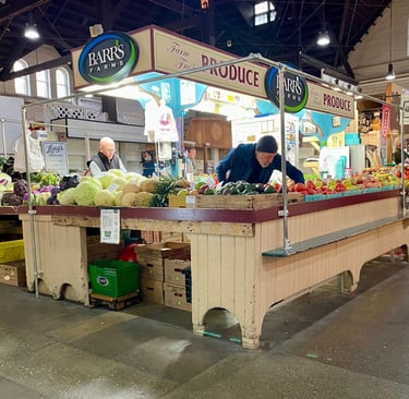 Market vendor arranging produce at a produce stand at Central Market in downtown Lancaster, Pennsylvania