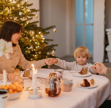 a woman and her son are sitting at a Christmas table