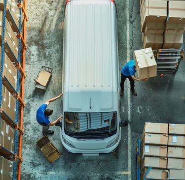 soluciones logísticas. Dos hombres poniendo carga a una camioneta de transporte y envío 