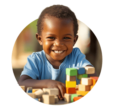 Child smiling with colourful blocks around him