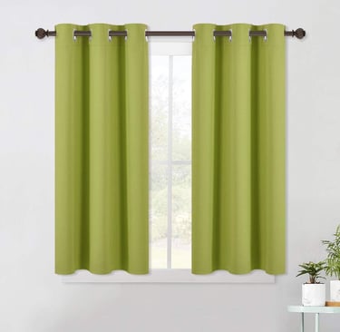 a green curtain with a window curtain and a potted plant