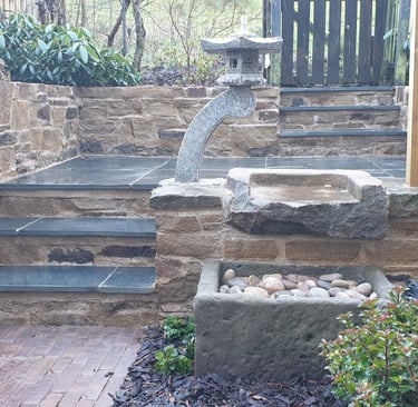 a stone fountain in the middle of a japanese style garden makeover in Yorkshire