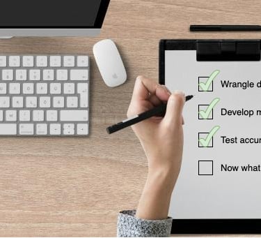 a person holding a pen and writing on a clipboard