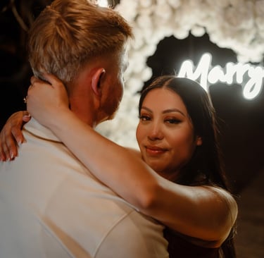 a man and woman standing in front of a neon sign