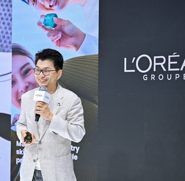 A L'Oréal speaker presenting corporate beauty technology at a business conference.