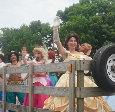 Princesses riding in a parade and waving