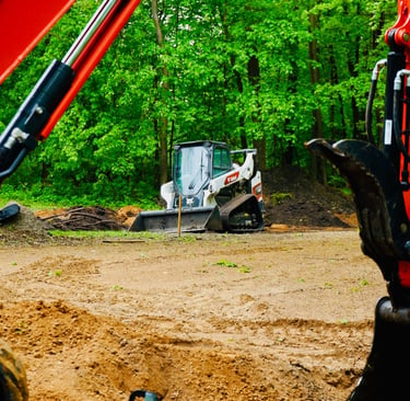bobcat skid steer grading gravel lot in central mn