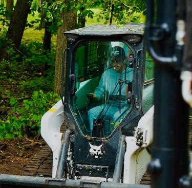 Owner, Patrick Kruse, in a bobcat skid steer grading dirt