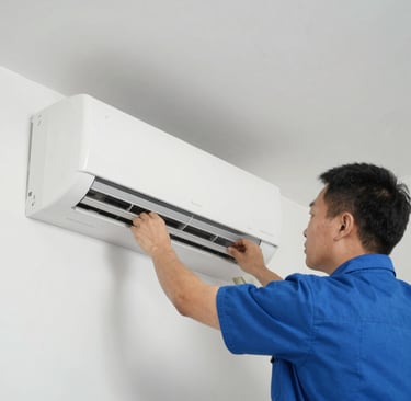 A cleaning cart is positioned in an outdoor area with a concrete building structure in the background. The cart holds a large bucket and cleaning supplies, including a striped cloth and a pink cloth hanging over the handle. A green scrubbing brush is placed on the bottom platform. Surrounding the area are vibrant flower beds with yellow and white flowers, as well as bushes and trees, contributing to a tidy and well-maintained environment.