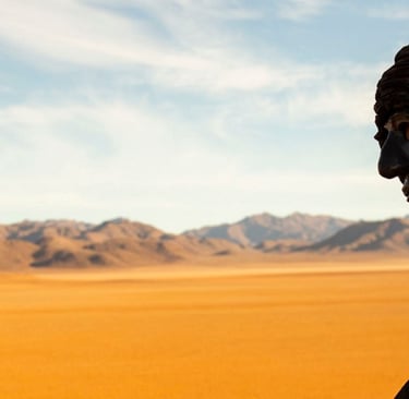 a man in a hoodedie standing in the desert