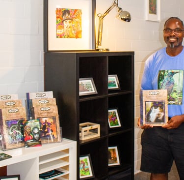 Smiling artist, David Thompson, showcasing EverLore books and colorful fantasy artwork in a modern g