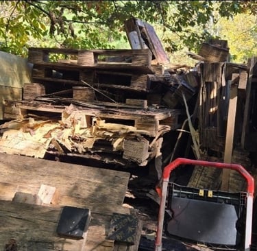Pld pallets, junk wood, trash and more on a residential property.