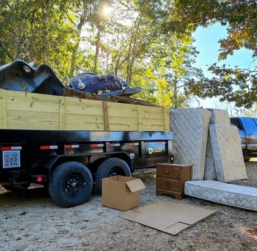Guaranteed Junk Removal's truck and dump trailer that is full of junk,  old mattresses, boxes, etc.