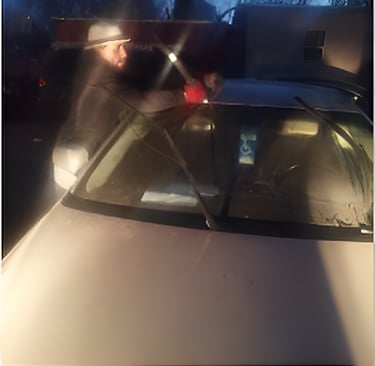 Technichian is working after dark on a windshield