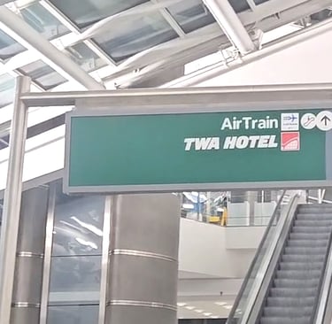 JFK terminal sign pointing to AirTrain and TWA Hotel