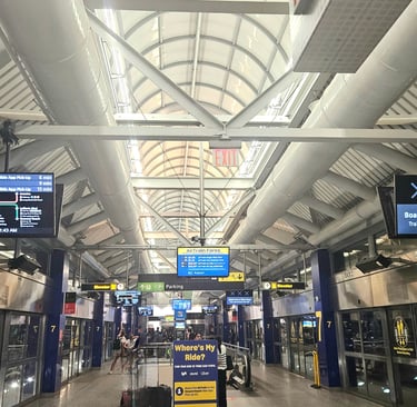 Terminal 7 AirTrain platform at JFK Airport showing route map and LIRR schedule to Manhattan