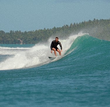 a man riding a wave in the ocean in mentawai