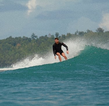 a man in a wetsuit surfing on a wave