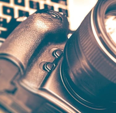 A modern DSLR camera paired with an interchangeable lens, arranged on a sleek surface to highlight learning photography