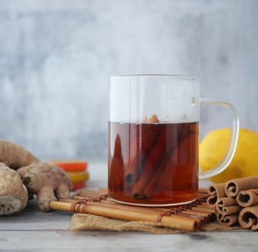 Ginger tea in a glass mug with cinnamon sticks