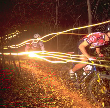 a man riding a bike at night on a trail