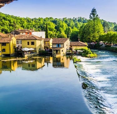Punto di vista panoramico di borghetto con varie case e fiume e alberi attorno