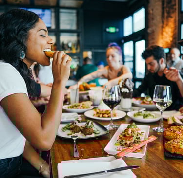 Enjoying great food with friends sharing delicious food in restaurant