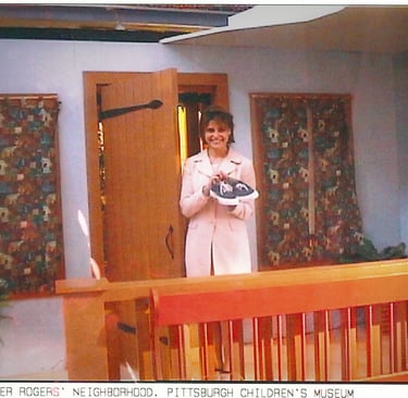 Angela Santomero holding Mister Rogers' sneakers on set in Pittsburgh, PA