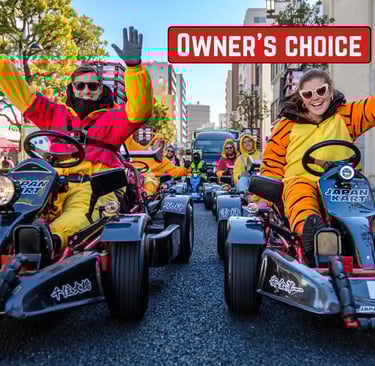 A couple wearing character-style costumes driving a street go-kart together in Japan