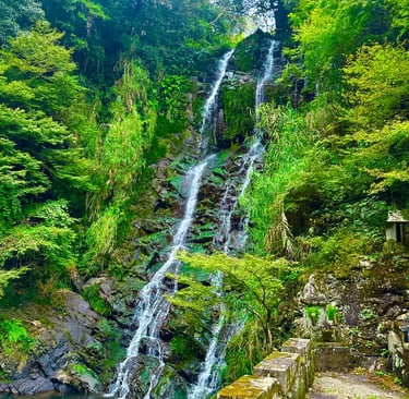 Twin waterfall flowing side by side in a forested valley in Nagasaki, creating a serene and spiritua