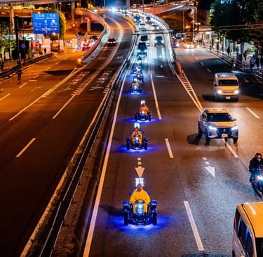 Street go-karts driving side by side on a city road at night in Japan