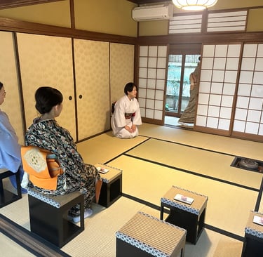 Two women wearing kimono sitting on chairs during a Japanese tea ceremony experience