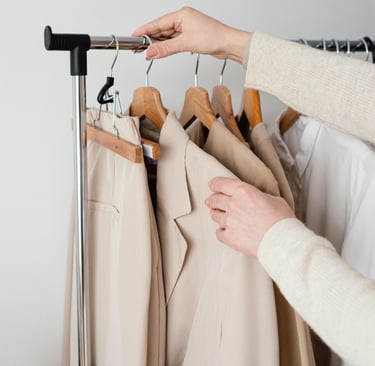 a person holding a rack of clothes and a coat, represents garderobe planning service