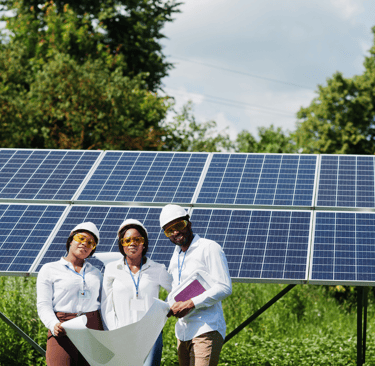 a group of people standing in front of a solar paneled solar array