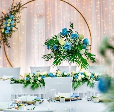 a table with a vase with flowers and a table with white chairs