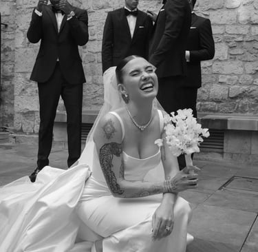 a bride holding a white bouquet of sweet peas and groomsmen are posing for a photo