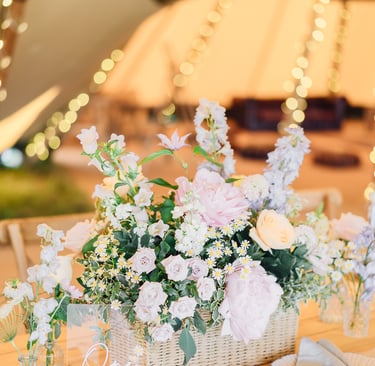 a table with a basket of pastel wild flowers
